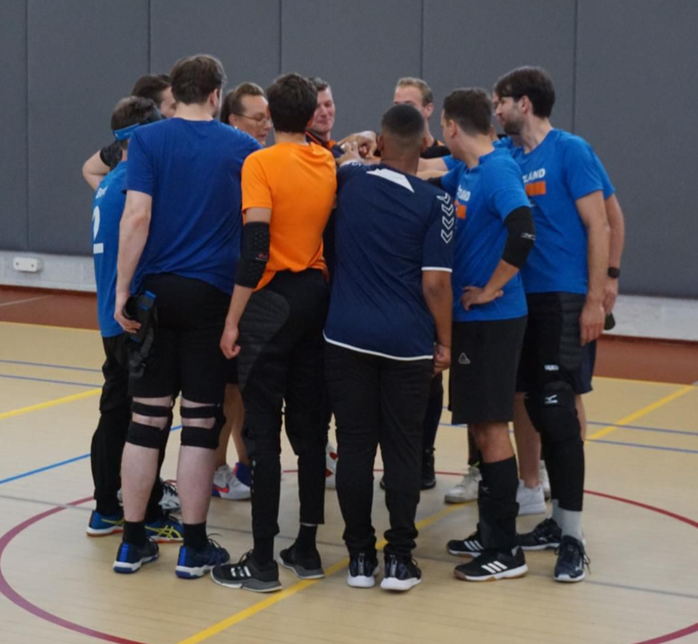 groepsfoto van de goalballheren die in een cirkel staan met hun handen bij elkaar, klaar voor een jel