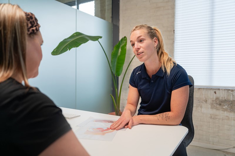 Fysiotherapeut Iris die een intake gesprek heeft met patiënt op locatie Doetinchem
