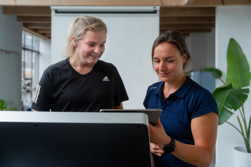 Sportfysiotherapeut Daphne aan het gesprek met een hardloopster in Doetinchem